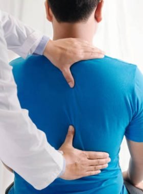 Doctor physiotherapist doing healing treatment on man's back.Back pain patient, treatment, medical doctor, massage therapist.office syndrome