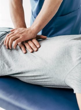 chiropractor massaging back of man on Massage Table in hospital